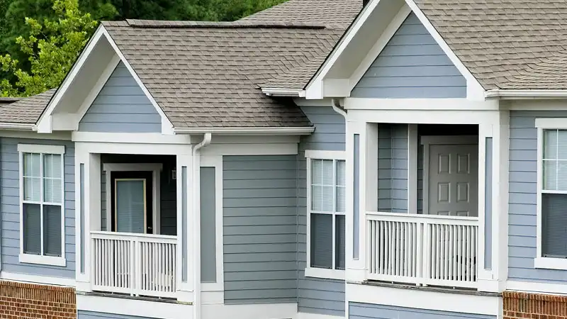A partial view of the top stories of an apartments or condos building with light blue siding and white trim represents the multi-unit exterior cleaning services offered by HurriClean Pressure Washing in the Louisville KY metro area.