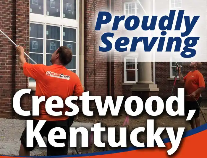 HurriClean Pressure Washing & Sealing technicians wearing bright orange company shirts soft washing a brick building with overlaid text that reads 'Proudly Serving Crestwood, Kentucky'.
