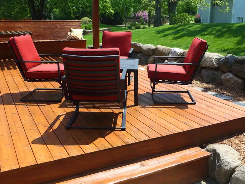 A residential wooden deck with a modern conversation set in the Jeffersontown KY area professionally restored and stained a warm golden color.