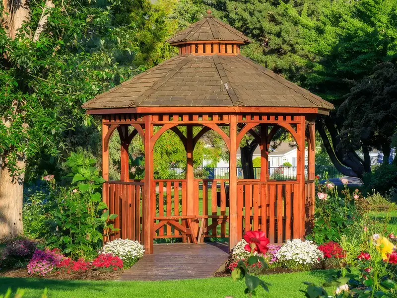 A garden setting wooden gazebo in the Taylorsville KY area stained a rich reddish orange color.